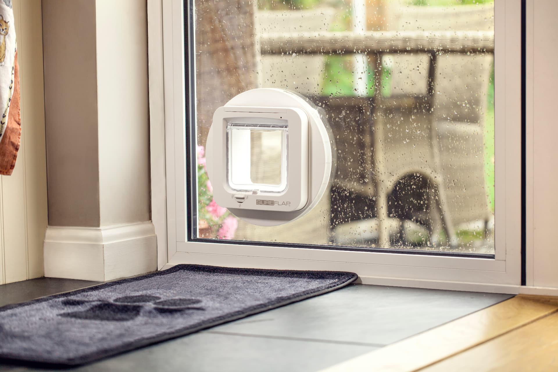 Close-up of a white SureFlap microchip cat flap fitted into a double-glazed patio door