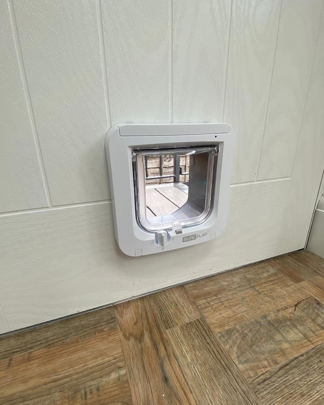SureFlap cat flap in a composite door looking out to a wooden deck
