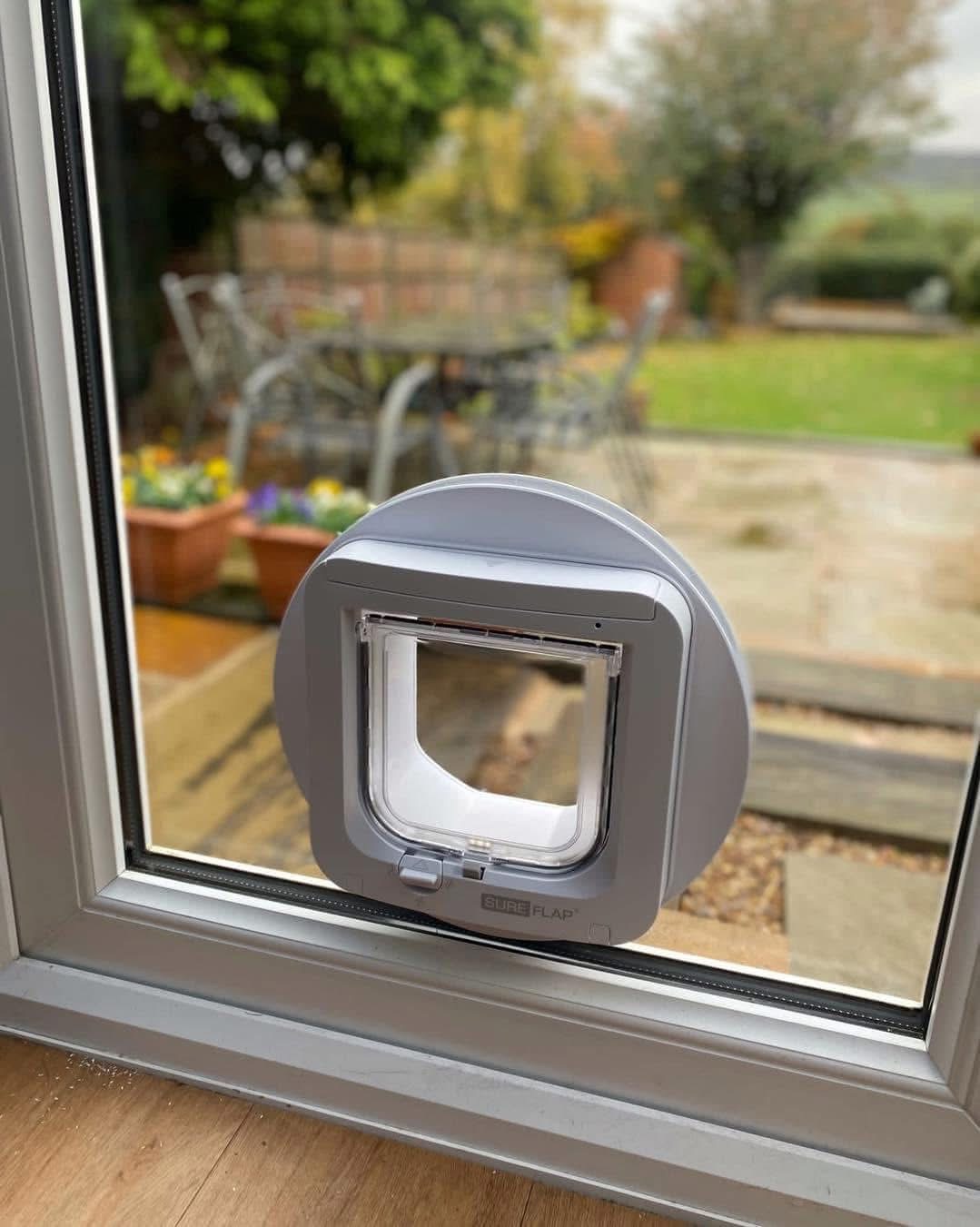 SureFlap microchip cat flap in a glass panel with garden view