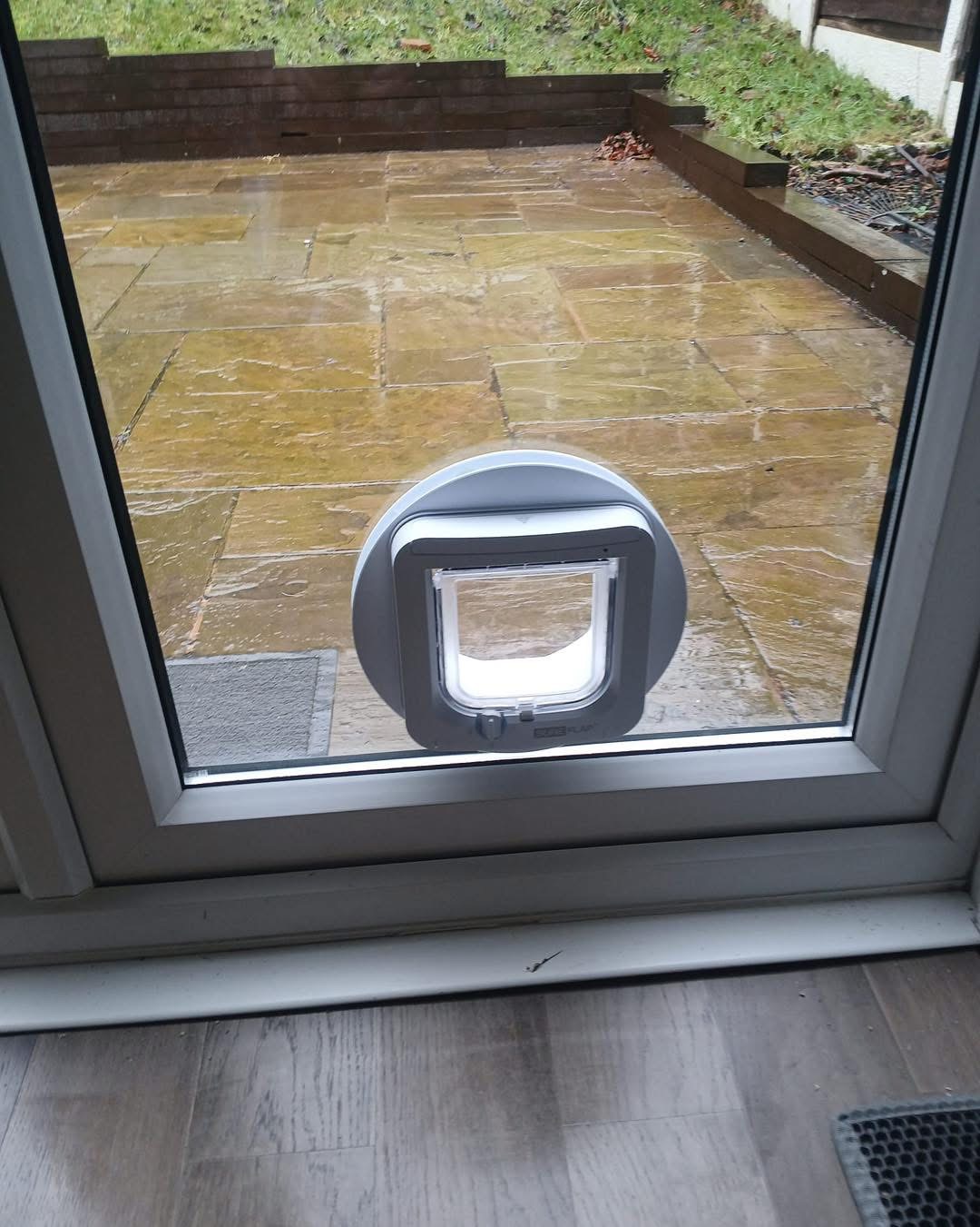 SureFlap cat flap in a patio door glass panel overlooking a stone patio